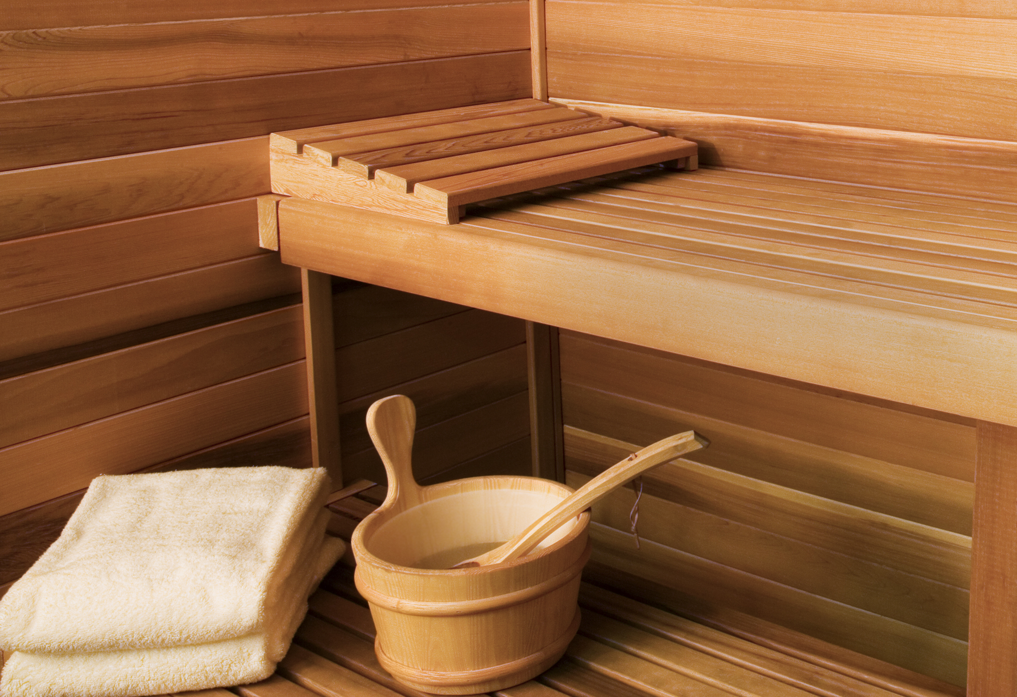 Close-up shot of inside of sauna showing bench, towels and pail.